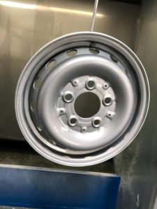 Repaired and refurbished steel alloy wheel with white colour change after